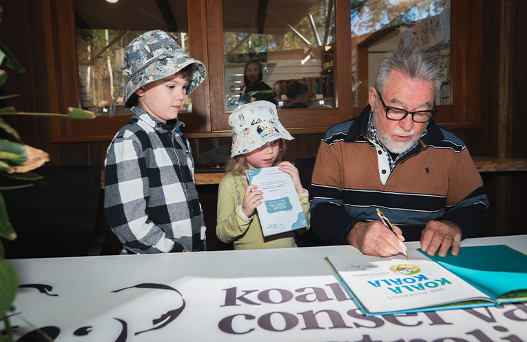 Signing a copy of the book for two fans.